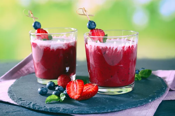 Glasses of berry smoothie on wooden table on blurred background — Stock Photo, Image