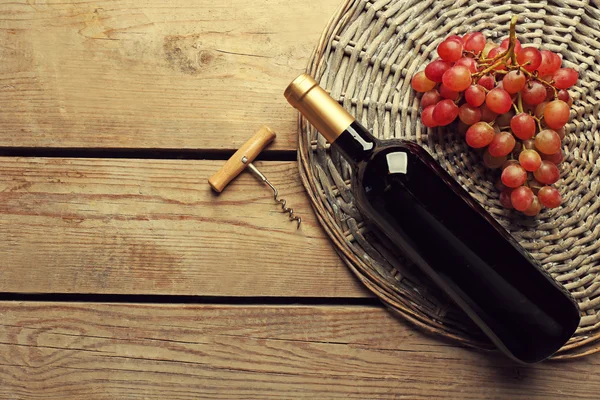 Botella de vino y uva sobre mesa de madera —  Fotos de Stock