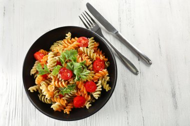 Lezzetli makarna yemek hizmet gri ahşap masa üzerinde siyah kase