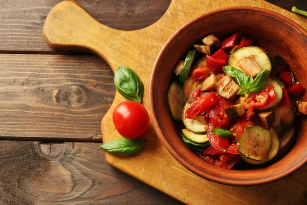 Tasty vegetarian ratatouille made of eggplants, squash, tomatoes in bowl on wooden table background — Stock Photo, Image