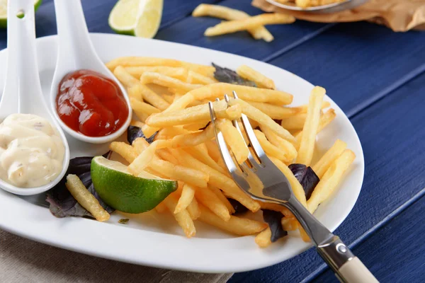 Frans gebakken aardappelen met saus en kalk op witte dienblad — Stockfoto