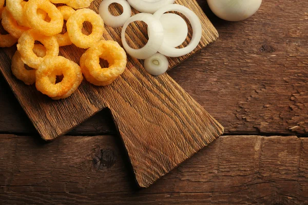 Anillos de virutas con salsa y cebolla en la tabla de cortar —  Fotos de Stock