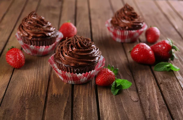 Cupcake al cioccolato e fragole su sfondo di legno — Foto Stock