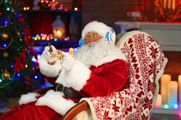 Santa Claus zitten met koptelefoon — Stockfoto