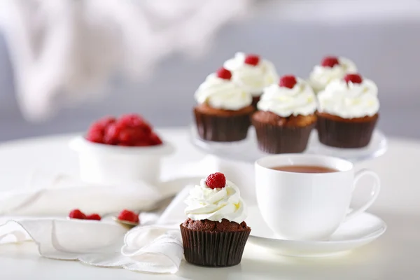 Gyönyörű csokoládé cupcakes és a csésze teát, a táblázat — Stock Fotó