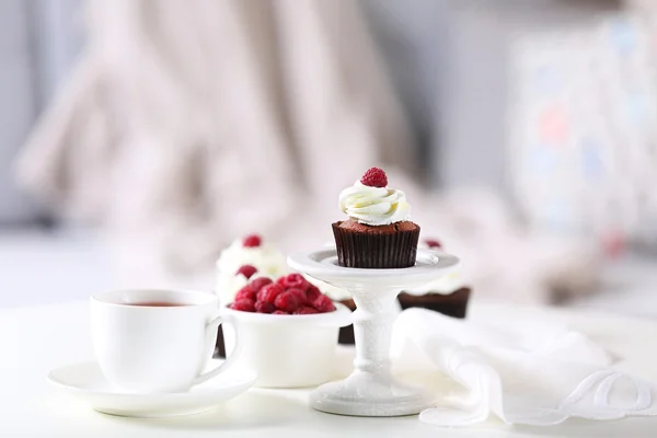 Schöne Schokoladen-Cupcakes mit Sahne und Himbeere auf dem Tisch — Stockfoto