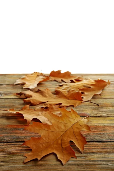 Κίτρινο το φθινόπωρο τα φύλλα σε ξύλινο τραπέζι, απομονωμένα σε λευκό — Φωτογραφία Αρχείου