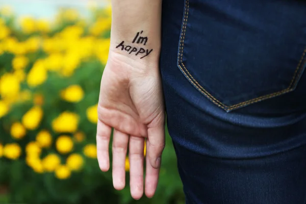 Hand av ung kvinna med tatuerade frasen — Stockfoto