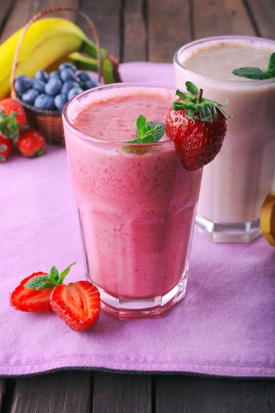 Glazen van verse koude smoothie met fruit en bessen, op tafel, close-up — Stockfoto