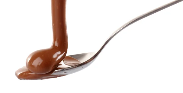 Melted milky brown chocolate pouring from a spoon, isolated on white — Stock Photo, Image