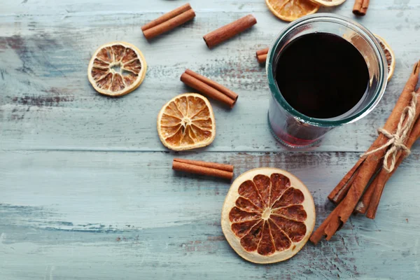 Gustoso vin brulè e spezie, su fondo di legno blu, primo piano — Foto Stock