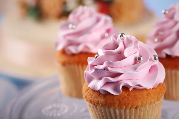 Gâteaux savoureux sur pied et gâteau, sur la table, sur fond de couleur — Photo