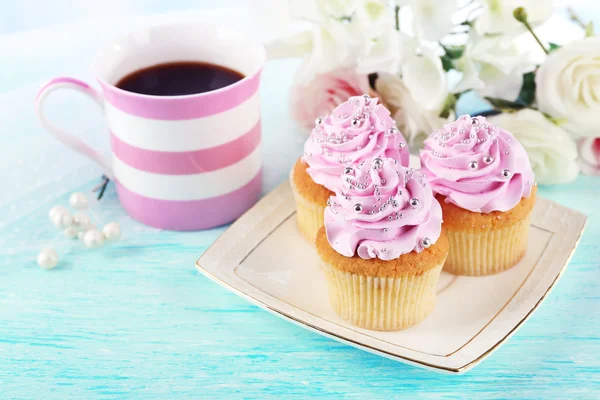 Smakelijke cupcakes op plaat, op lichte achtergrond — Stockfoto