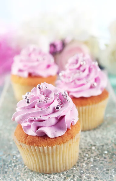 Smakelijke cupcakes op plaat, op een houten achtergrond kleur — Stockfoto