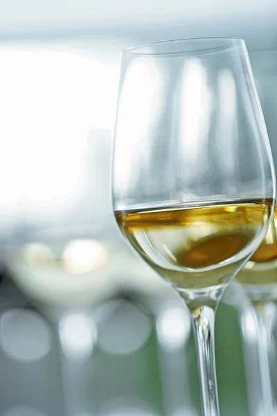 Bicchieri da vino con vino bianco e rosso su tavolo di legno su sfondo brillante — Foto Stock