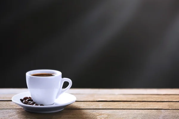 Xícara de grãos de café e café em mesa de madeira, em fundo cinza — Fotografia de Stock
