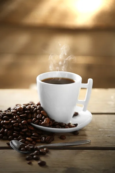 Xícara de grãos de café e café em fundo de madeira — Fotografia de Stock