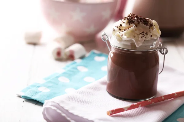 Glass jar of chocolate milk on table close-up — Stock Photo, Image