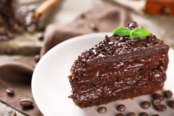 Pastel de chocolate con crema de chocolate y bayas frescas en el plato, sobre fondo de madera — Foto de Stock