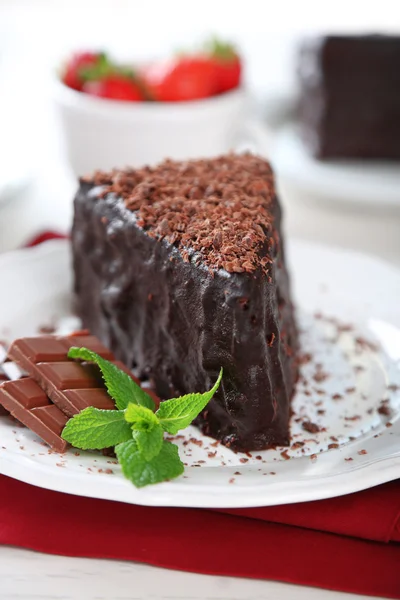Gâteau au chocolat avec crème au chocolat sur assiette, sur fond clair — Photo