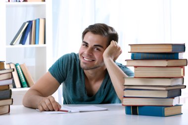 Genç adam masada kitap okumak
