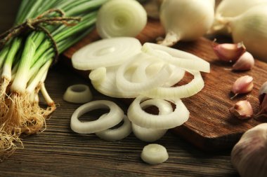 Soğan halkaları, ahşap arka plan karşı gemide sarımsaklı taze yeşil soğan