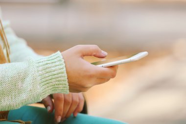 Kadın eli cep telefonu tutuyor.