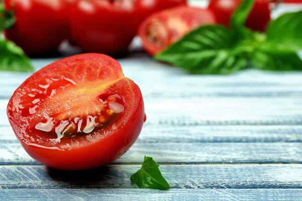 Tomates frescos con albahaca sobre mesa de madera de cerca — Foto de Stock