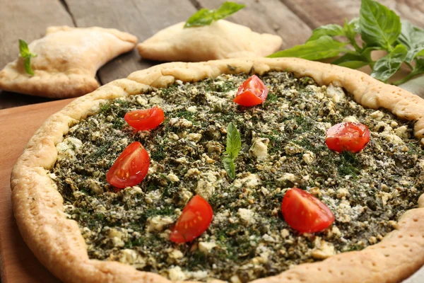 Offene Torte mit Spinat und Tomatenkirsche auf dem Tisch aus nächster Nähe — Stockfoto