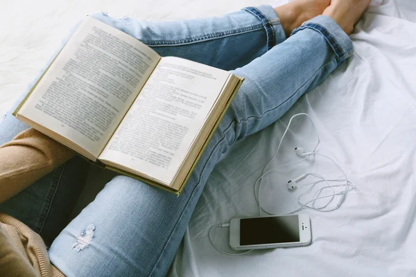 Frau in Jeans auf dem Bett — Stockfoto