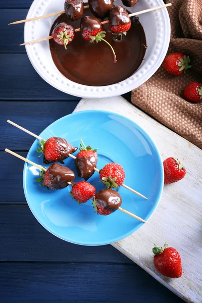 Delicious strawberries in chocolate on kitchen table — Stock Photo, Image