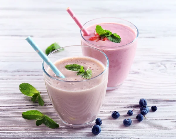 Fragole fresche e yogurt al latte con menta su fondo di legno chiaro — Foto Stock