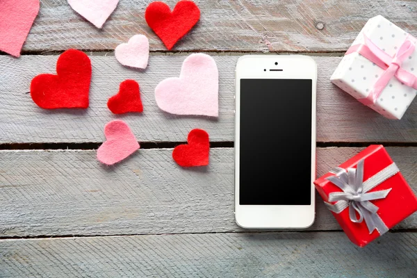 Teléfono con pantalla en blanco y corazones — Foto de Stock