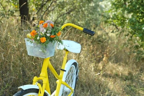 Bicicleta amarela com buquê de flores — Fotografia de Stock