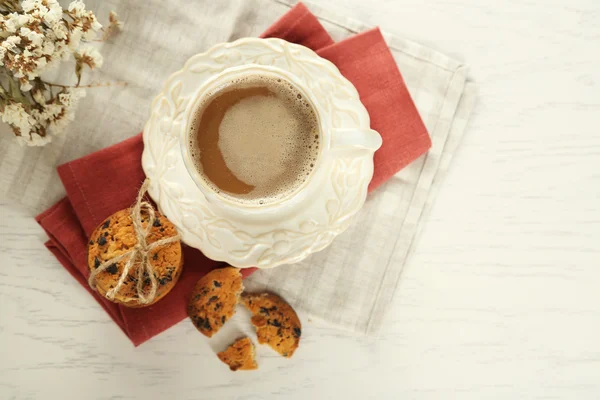 Fincan kahve ve çikolata kırıntıları Beyaz ahşap masa üzerinde lezzetli Kurabiye yığını — Stok fotoğraf