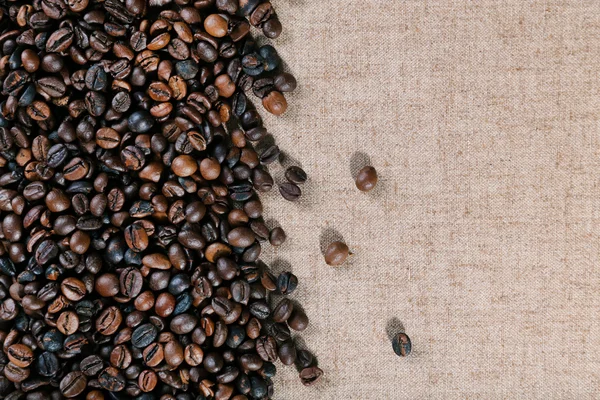 Grains de café torréfiés sur le tissu de lin — Photo