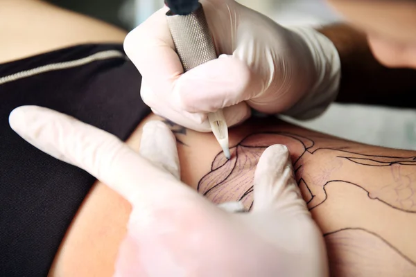 Hands in medicine gloves make tattoo — Stock Photo, Image