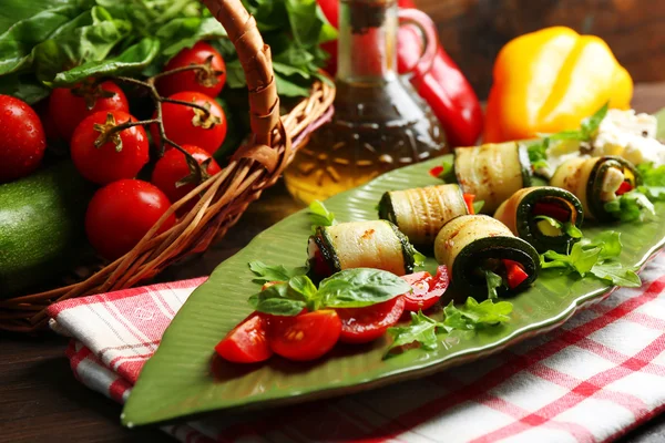 Rolos de abobrinha com queijo, pimentão e arugula na placa, close-up, no fundo da mesa — Fotografia de Stock