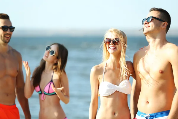 Pareja feliz y amigos relajándose en la playa — Foto de Stock