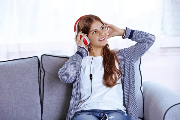 Menina bonita ouvindo música no sofá — Fotografia de Stock