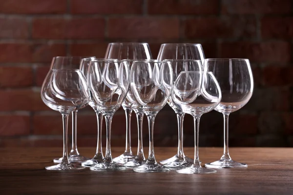 Verre à vin vide sur une table sur un fond de mur de briques — Photo