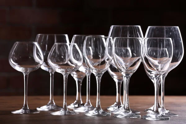 Vaciar copas de vino sobre una mesa sobre un fondo de pared de ladrillo — Foto de Stock