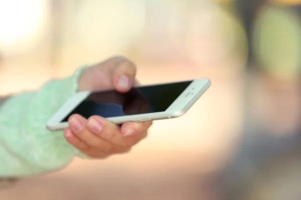 Mano femenina sosteniendo un teléfono móvil — Foto de Stock