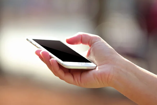 Weibliche Hand hält ein Mobiltelefon — Stockfoto
