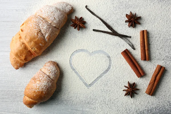 Herz aus Mehl, Croissant und Gewürzen auf grauem Hintergrund — Stockfoto