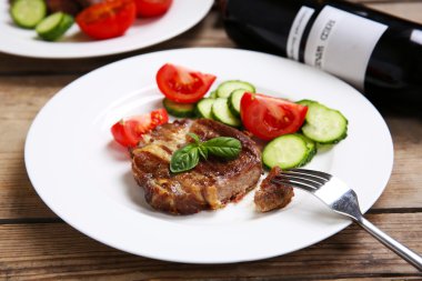 Kavrulmuş sığır filetosu ve ahşap arka plan üzerinde plaka üzerinde taze sebze