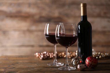 Kırmızı şarap ve ahşap masa ahşap arka plan üzerinde Noel süsler