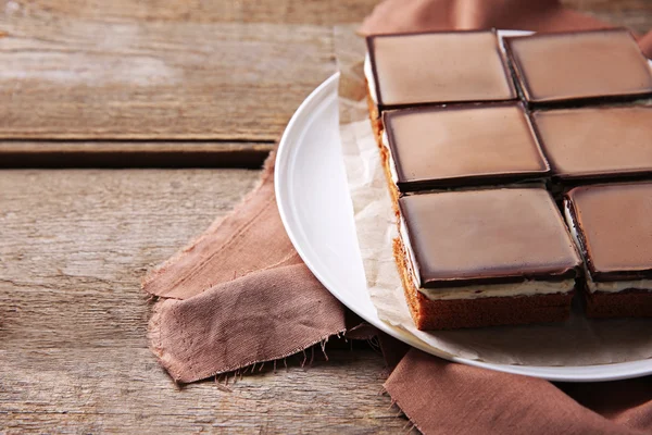 Läcker choklad brownies på plattan, på trä bakgrund — Stockfoto