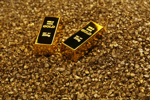 Gold bars on nugget grains background — Stock Photo, Image