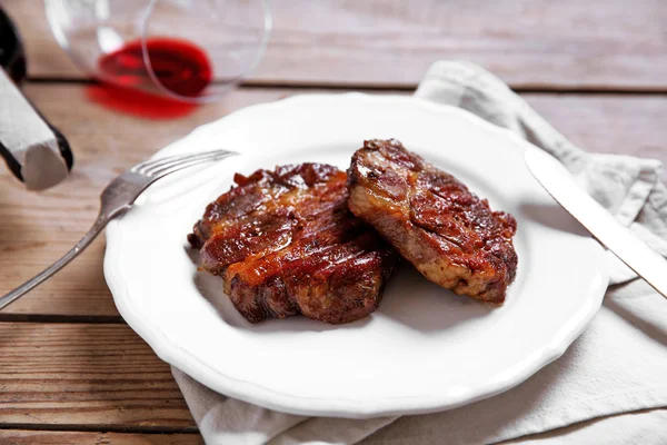 Roasted beef fillet on plate, on wooden background — Stock Photo, Image